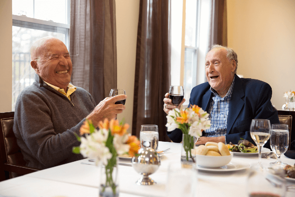 Male residents at dinner table with wine glasses