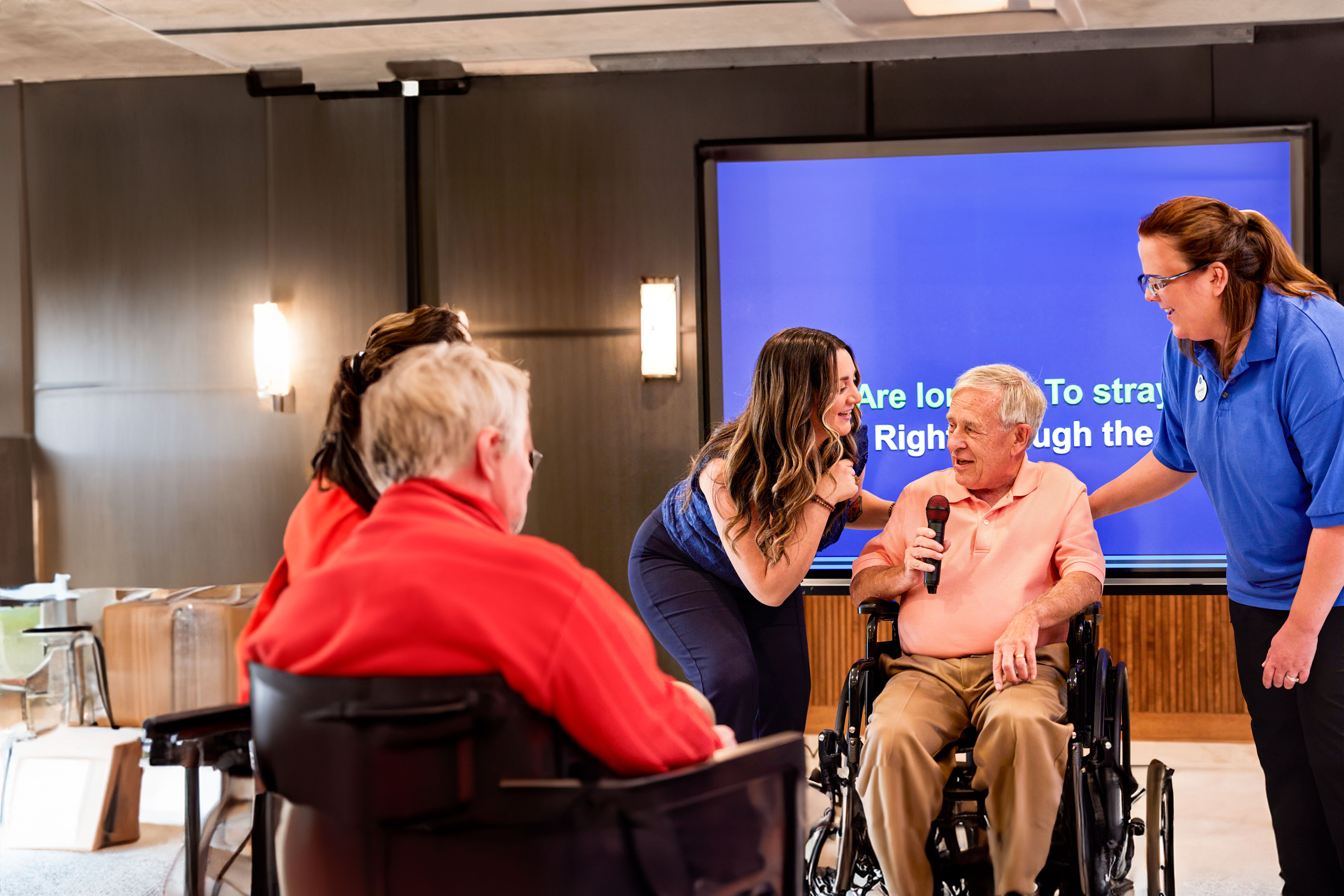 Senior living activities director and assistant with a resident during an activity